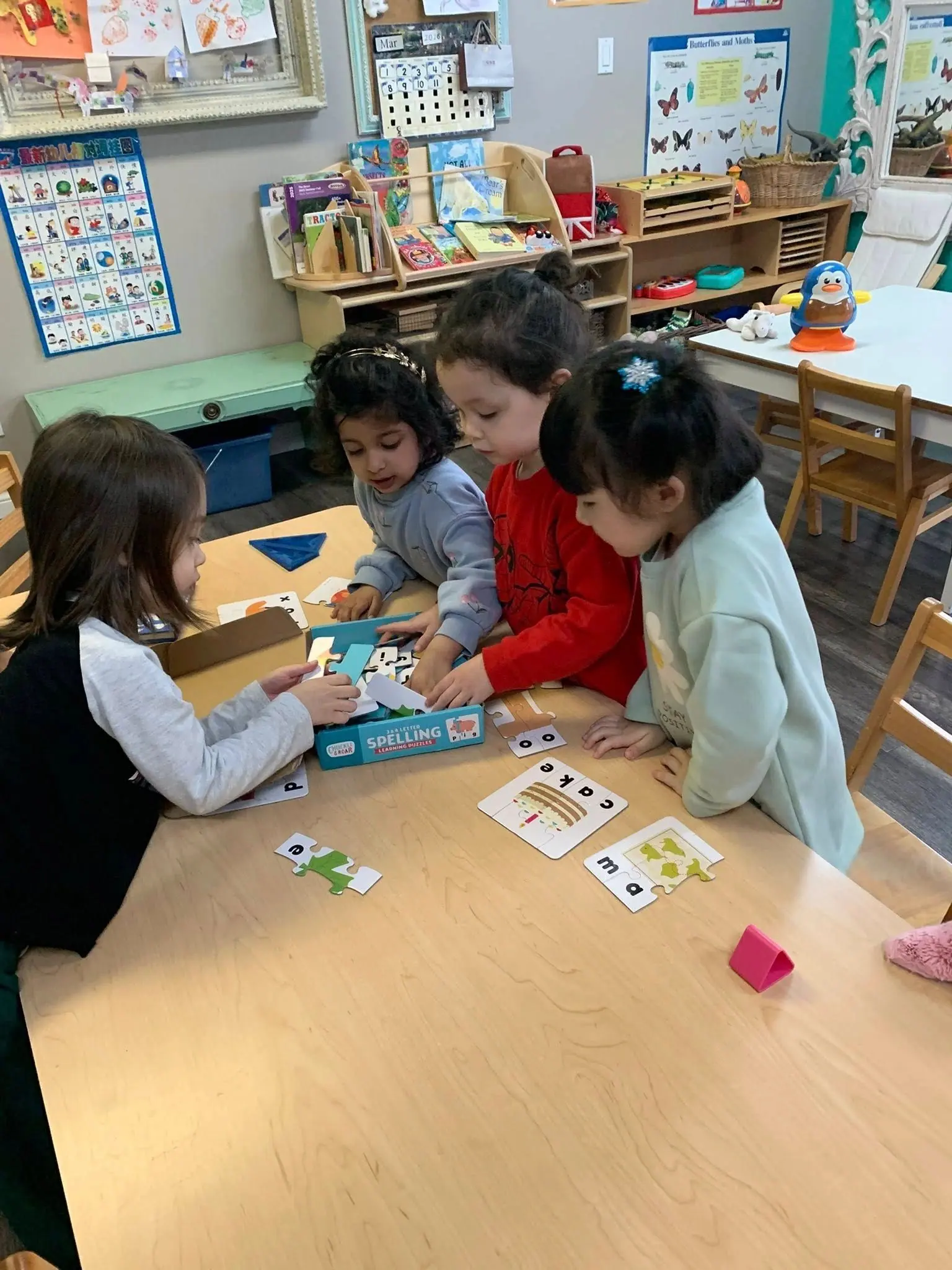 Four children playing a picture-card matching game together at the table